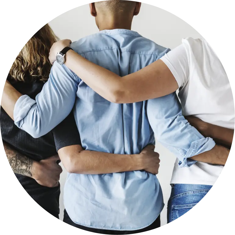 Colleagues standing together with their arms around one another